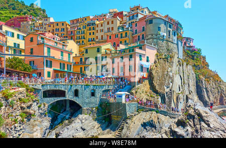 Manarola, La Spezia, Italien - Juli 2, 2019: Waterfront mit wandern Menschen in Manarola kleine Stadt auf sonnigen Sommertag, Cinque Terre Stockfoto