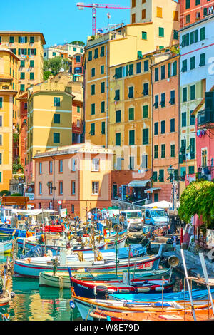 Camogli, Genua, Italien - Juli 3, 2019: Farbenfrohe Gebäude und Fischerboote im Hafen von Camogli an sonnigen Sommertagen, Ligurien Stockfoto