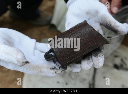 Ein archäologe zeigt Bianzhong, eine alte chinesische Musikinstrument, bestehend aus einer Reihe von Bronze Glockenspiel, nachdem es ausgraben aus der Tomb dating b Stockfoto