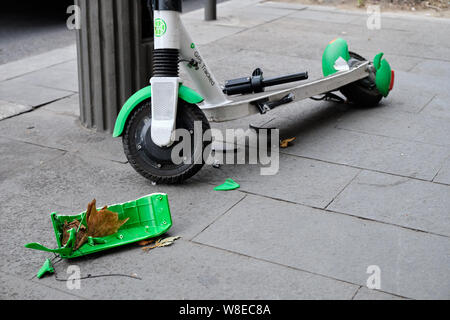 Nahaufnahme der Schwer beschädigte shared Elektroroller auf bürgersteig folgenden crash Links. Stück verstreut und Thorn zurück Rad. Bukarest, Rumänien, Stockfoto