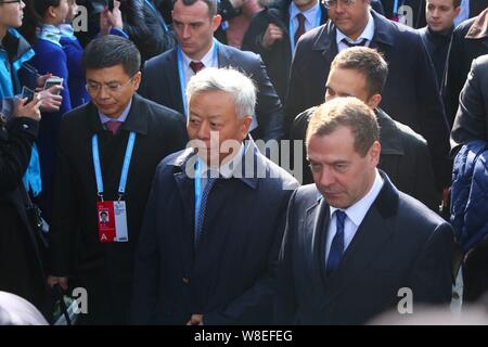 Der russische Ministerpräsident Dimitri Medwedew, rechts, und Jin Liqun, Zentrum, gewählter Präsident der Asiatischen Infrastructure Investment Bank, verlassen nach attendi Stockfoto