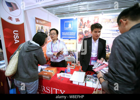 ------ Chinesischer Besucher sprechen mit Ausbildung Berater am Stand der Universität von Dayton und Aston Akademie in der 'Study in USA' Bereich während der Stockfoto