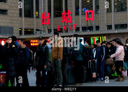 Chinesische Passagiere, die Rückkehr aus dem Chinesischen Neujahrsfest oder Spring Festival warten Taxis zu arbeiten nach dem Verlassen der Beijing Railway Station Beij Stockfoto