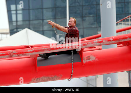 Kanadische entfesselungskünstler Dekan Gunnarson versucht, sich von den Ketten auf der Spur der Achterbahn während einer Flucht zeigen im Happy Valley in den freien Stockfoto