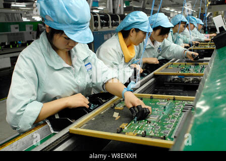 ------ Weibliche chinesische Arbeiter Einbau der elektronischen Komponenten auf integrierte Leiterplatten im Werk von Dongguan Alpha Electronic Co., Ltd. in Dongg Stockfoto