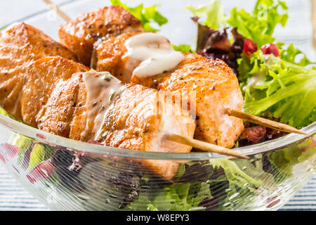 Gegrillter Lachs Spieße mit Sommer Salat Salat pomehranate Samen Olivenöl und Dressing. Gesunde Fische essen mit Obst und Gemüse Stockfoto