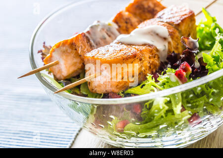 Gegrillter Lachs Spieße mit Sommer Salat Salat pomehranate Samen Olivenöl und Dressing. Gesunde Fische essen mit Obst und Gemüse Stockfoto