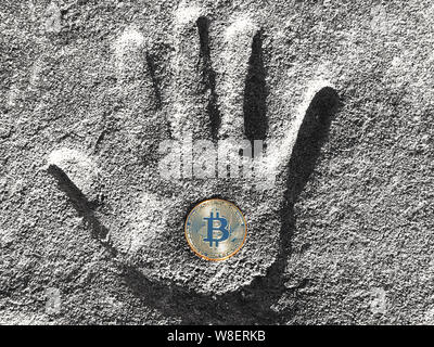 Cryptocurrency Konzept, bitcoin Münze liegt ein handabdruck in Zement. Von oben nach unten anzeigen Stockfoto