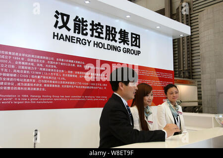 ------ Chinesische Mitarbeiter sind auf dem Stand von Hanergy Holding Gruppe während der 7 (2013) International Photovoltaic Power Generation Conference gesehen Stockfoto