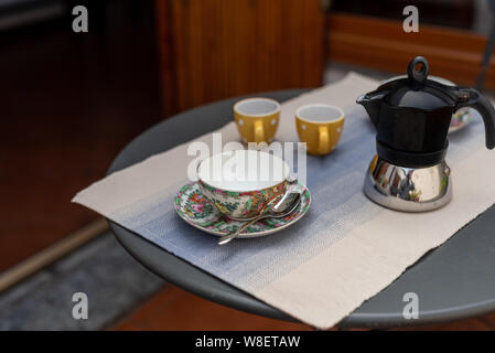 Eine Reihe von eingerichtet Kaffee Tassen und eine Kaffeemaschine, einen Tisch für das Frühstück, Interior Design auf einem Balkon Stockfoto