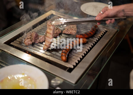 Verschiedene Arten von Fleisch, Rindfleisch Steaks und Würstchen, gekocht auf dem Grill innen Stockfoto