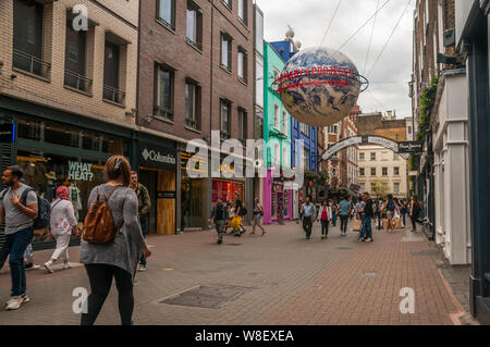 Käufer und Touristen zu Fuß entlang der Carnaby Street in London. Stockfoto