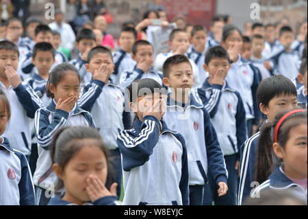 Junge chinesische Studenten lernen Handzeichen für die Alarmierung Raucher an einer Schule in Peking, China, 11. Mai 2015. Studenten in Peking starten Stockfoto