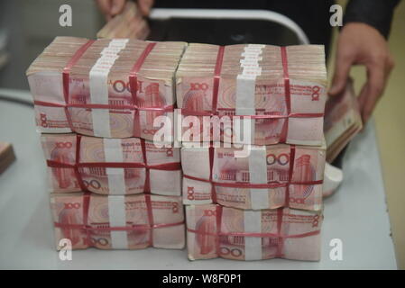 ---- Eine chinesische Angestellte verwendet eine Cash - Zählmaschine RMB (Renminbi) Yuan Banknoten bei einer Bank in der Stadt Qionghai zu zählen, South China Hainan Provinz, Stockfoto