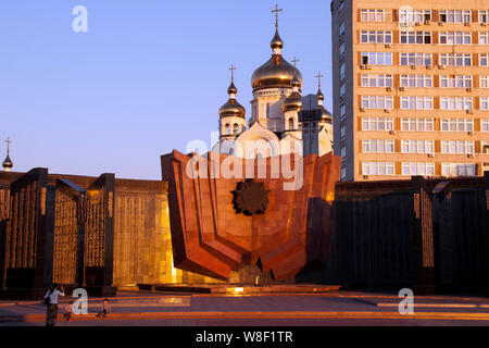 Khabarovsk Russland, Denkmal für die Gefallenen in den Kriegen mit Dom im Hintergrund in der Dämmerung Stockfoto