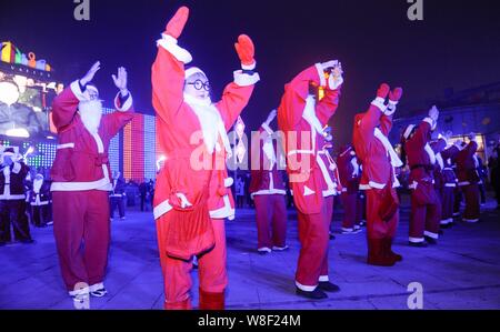 Animateure gekleidet in Santa Claus Kostüme durchführen in einem Flash Mob Weihnachten in Peking, China zu feiern, 24. Dezember 2015. Stockfoto