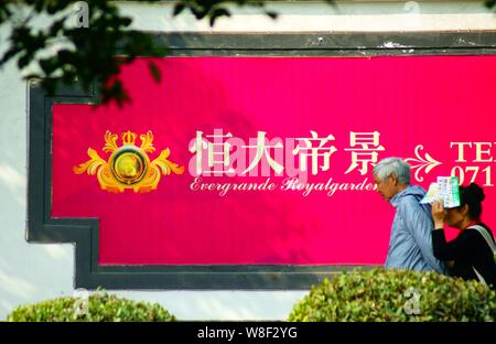 ---- Fußgänger vorbei an einer Werbung für Evergrande Royalgarden, eine Wohn- Projekt von Evergrande Real Estate Group entwickelt, habe ich Stockfoto