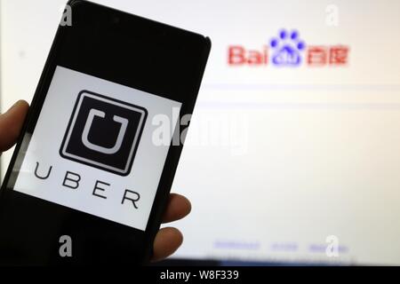 ---- Handy Benutzer schaut auf ein Logo von Taxi-hageln app Uber auf seinem Smartphone in Shanghai, China, 24. Dezember 2014. Uber Technologies Inc., Stockfoto