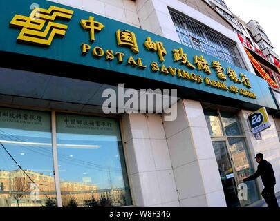 ---- Ein Kunde geht auf eine Filiale der Postsparkasse Chinas in Qiqihar City, im Nordosten Chinas Provinz Heilongjiang, 28. Dezember 2013. Stockfoto