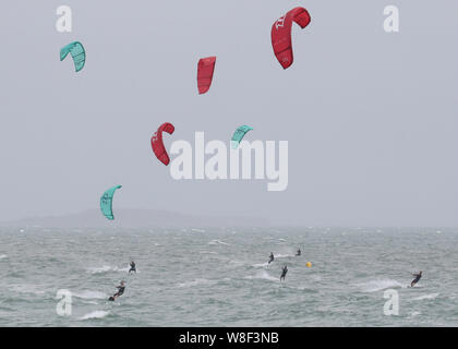 Kite Surfer genießen Sie die starken Winde aus der Branksome Chine, in der Nähe von Poole in Dorset. Warnungen für Regen und Wind in Kraft trat heute in fast allen UK. Stockfoto