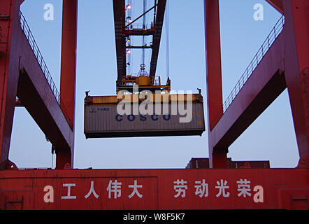 ------ Kran Fahrzeug entlädt einen Behälter mit cosco am Hafen der Stadt Rizhao Rizhao in der ostchinesischen Provinz Shandong, 5. April 2014. Liefer- ein Stockfoto