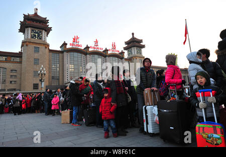 Chinesische Passagiere, die Rückkehr aus dem Chinesischen Neujahrsfest oder Spring Festival warten Taxis zu arbeiten nach dem Verlassen der Beijing Railway Station Beij Stockfoto