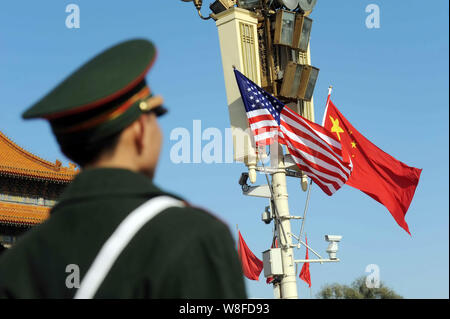 ---- Einen Chinesischen paramilitärischen Polizist wacht vor Chinesischen und US National Fahnen flattern auf einer Strassenlaterne während des Besuchs von US-Pres Stockfoto