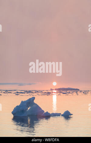 Arktische Natur Landschaft mit Eisbergen in Grönland eisfjord mit dem Midnight Sun Sonnenuntergang / Sonnenaufgang am Horizont. Am frühen Morgen Sommer alpenglow während Stockfoto