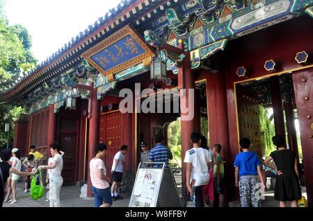 ---- Fußgänger für Fotos vor einem Tor der Peking Universität in Peking, China, 17. August 2013 darstellen. Der Tsinghua Universität Peking und Univer Stockfoto