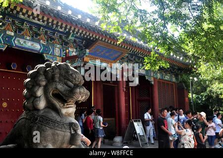 ---- Fußgänger für Fotos vor einem Tor der Peking Universität in Peking, China, 17. August 2013 darstellen. Nach den Ergebnissen aus der UK-bas Stockfoto