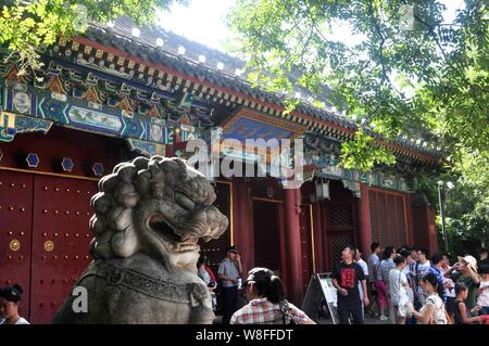 ---- Fußgänger für Fotos vor einem Tor der Peking Universität in Peking, China, 17. August 2013 darstellen. Die beiden oberen Festland Universitäten stieg Stockfoto