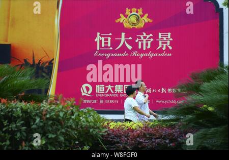 ---- Fußgänger vorbei an einer Werbung für Evergrande Royalgarden, eine Wohn- Projekt von Evergrande Gruppe, in Yichang ci entwickelt. Stockfoto