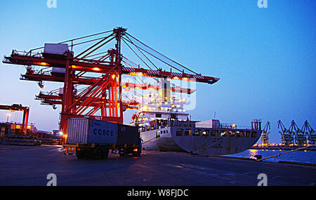 ---- Ein LKW-Transporte einen Behälter mit Cosco auf einem Kai am Hafen der Stadt Rizhao Rizhao in der ostchinesischen Provinz Shandong, 5. April 2014. Shippi Stockfoto