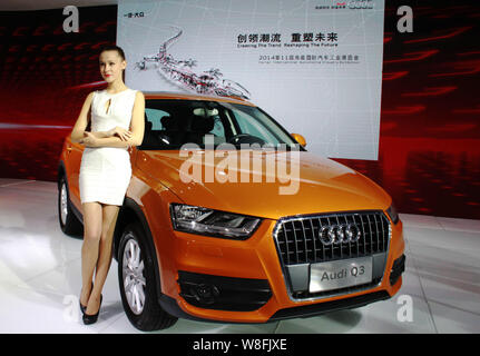 ---- Ein Modell stellt mit einem Audi Q3 bei einem Automobil Ausstellung in Stadt Haikou, South China Hainan Provinz, 22. März 2014. Für einige auto ma Stockfoto