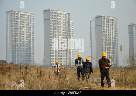 ------ Chinesische Wanderarbeiter vorbei neue High-rise apartment Gebäude in eine Wohn- Projekt in Nanjing, China Jiangsu pr Stockfoto