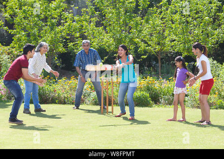 Familie spielen Cricket in Rasen Stockfoto