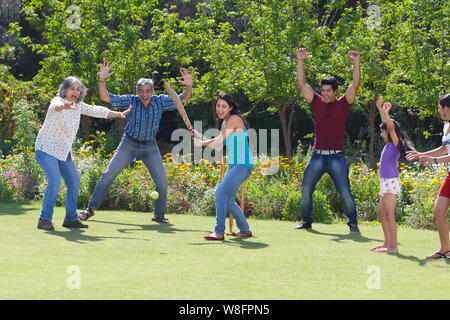 Familie spielen Cricket in Rasen Stockfoto