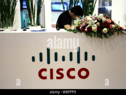 ---- Ein chinesischer Mitarbeiter ist auf dem Stand von Cisco Systems während einer Messe in Chongqing, China, 17. Mai 2014 gesehen. Cisco Systems am Mittwoch (11. Feb. Stockfoto