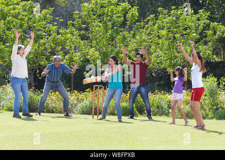 Familie spielen Cricket in Rasen Stockfoto