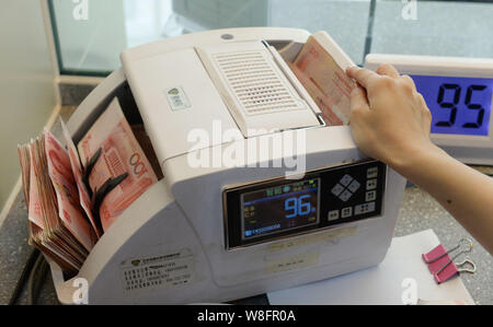 ---- Eine chinesische Angestellte verwendet eine Cash - Zählmaschine RMB (Renminbi) Yuan Banknoten bei einer Bank in Nanchong City zu zählen, im Südwesten Chinas Sichuan prov Stockfoto