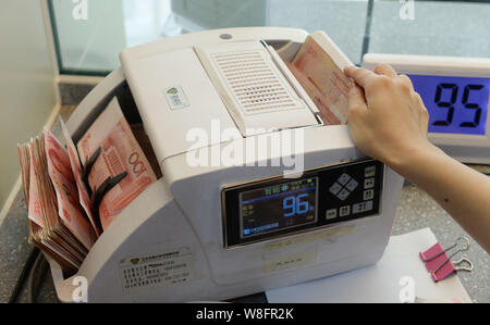 ---- Eine chinesische Angestellte verwendet eine Cash - Zählmaschine RMB (Renminbi) Yuan Banknoten bei einer Bank in Nanchong City zu zählen, im Südwesten Chinas Sichuan prov Stockfoto