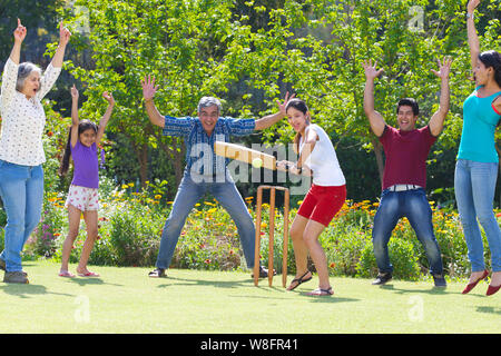 Familie spielen Cricket in Rasen Stockfoto