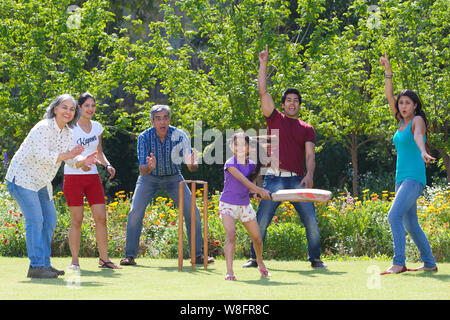 Familie spielen Cricket in Rasen Stockfoto