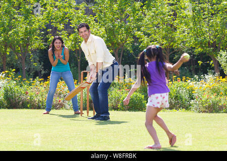 Familie spielen Cricket in Rasen Stockfoto