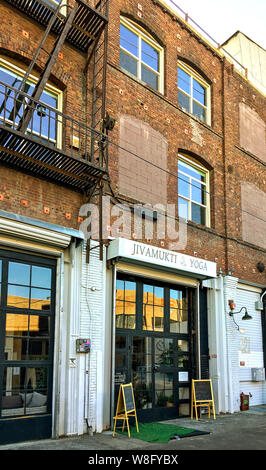 Los Angeles, CA/USA - 12. April 2019: Die gentrifizierung im Arts District. Ein 1909 Lager umgewandelt in das Yoga Studio in der Innenstadt von Los Angeles. Stockfoto