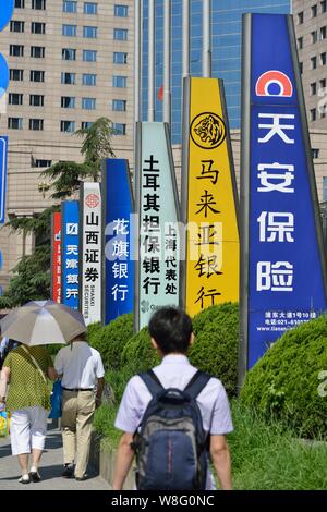 ---- Fußgänger vorbei an Schildern von chinesischen und ausländischen Banken und anderen Finanzinstituten in der Lujiazui Finanzviertel in Pudong, S Stockfoto