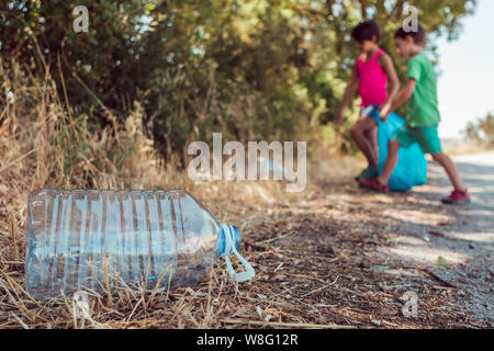 Kinder Abholung Müll im Wald mit einer Plastiktüte. Ehrenamt, Nächstenliebe und Ökologie Konzept. Stockfoto