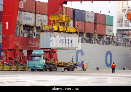 ------ Kran Fahrzeug entlädt der COSCO Container auf einem Lastwagen am Hafen der Stadt Rizhao Rizhao in der ostchinesischen Provinz Shandong, 31. Januar 2015. Stockfoto