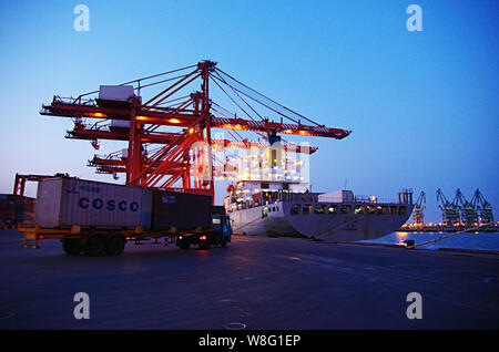 ---- Ein LKW-Transporte einen Behälter mit Cosco auf einem Kai am Hafen der Stadt Rizhao Rizhao in der ostchinesischen Provinz Shandong, 5. April 2014. Wie Chi Stockfoto