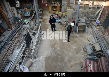 Chinesischen Strafverfolgungsbehörden prüfen die Verfüllung eines 3-level und 700 m² großen Keller illegal von Haus in Shaluo Hütte gebaut Stockfoto